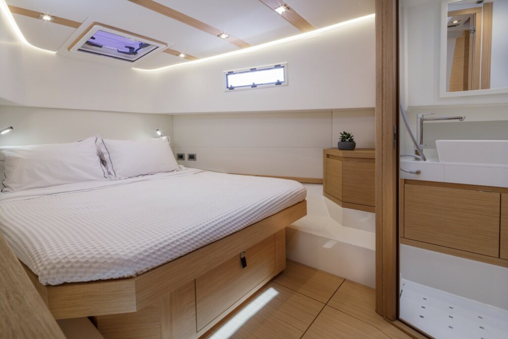 Bright and modern interior of Wai, featuring a master cabin with a double bed and a second cabin with twin beds.