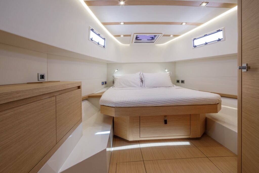 Bright and modern interior of Wai, featuring a master cabin with a double bed and a second cabin with twin beds.