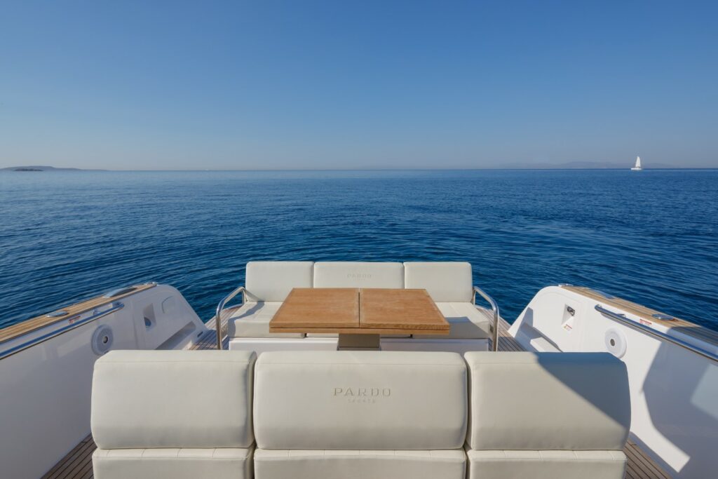 Elegant open-air dining area at the stern of Wai, set with a foldable table and seating for six guests.