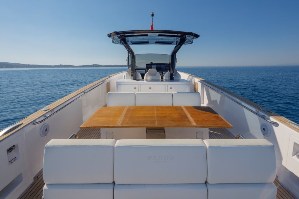 Elegant open-air dining area at the stern of Wai, set with a foldable table and seating for six guests.