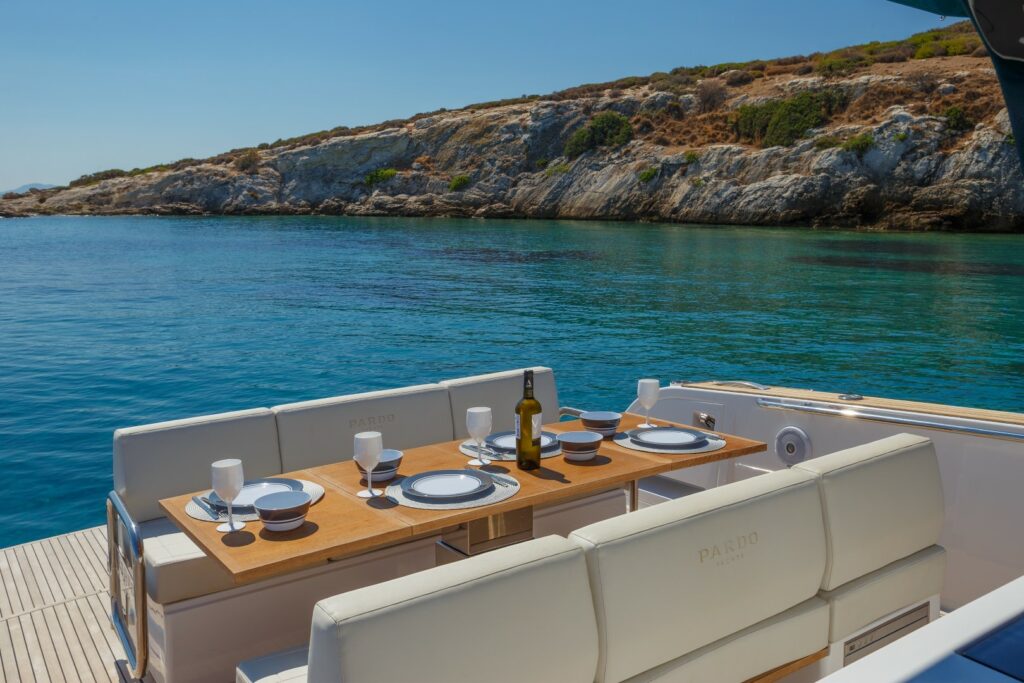 Elegant open-air dining area at the stern of Wai, set with a foldable table and seating for six guests.