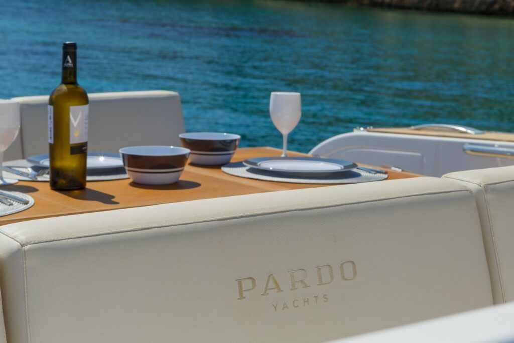 Elegant open-air dining area at the stern of Wai, set with a foldable table and seating for six guests.