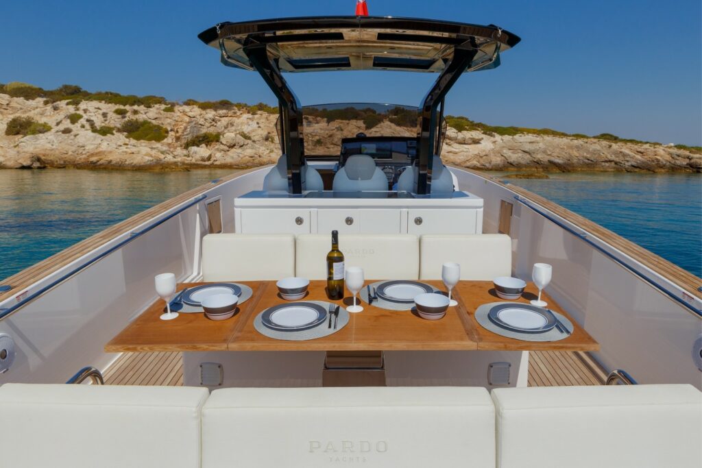 Elegant open-air dining area at the stern of Wai, set with a foldable table and seating for six guests.