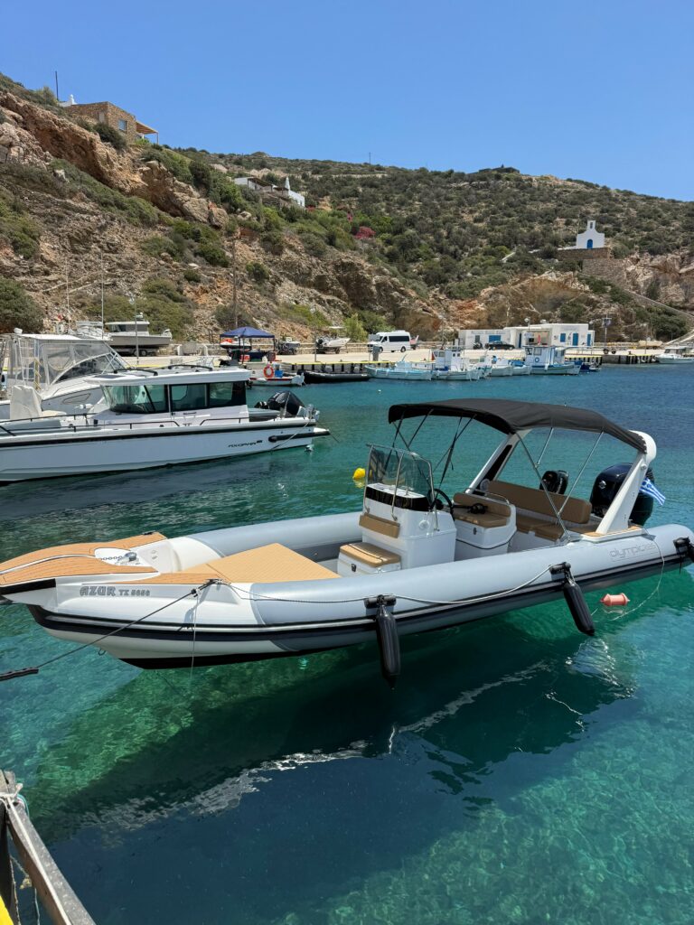 A La Mer Azur — boat rental anchored in Cheronissos bay, Sifnos, below the whitewashed hilltop chapel