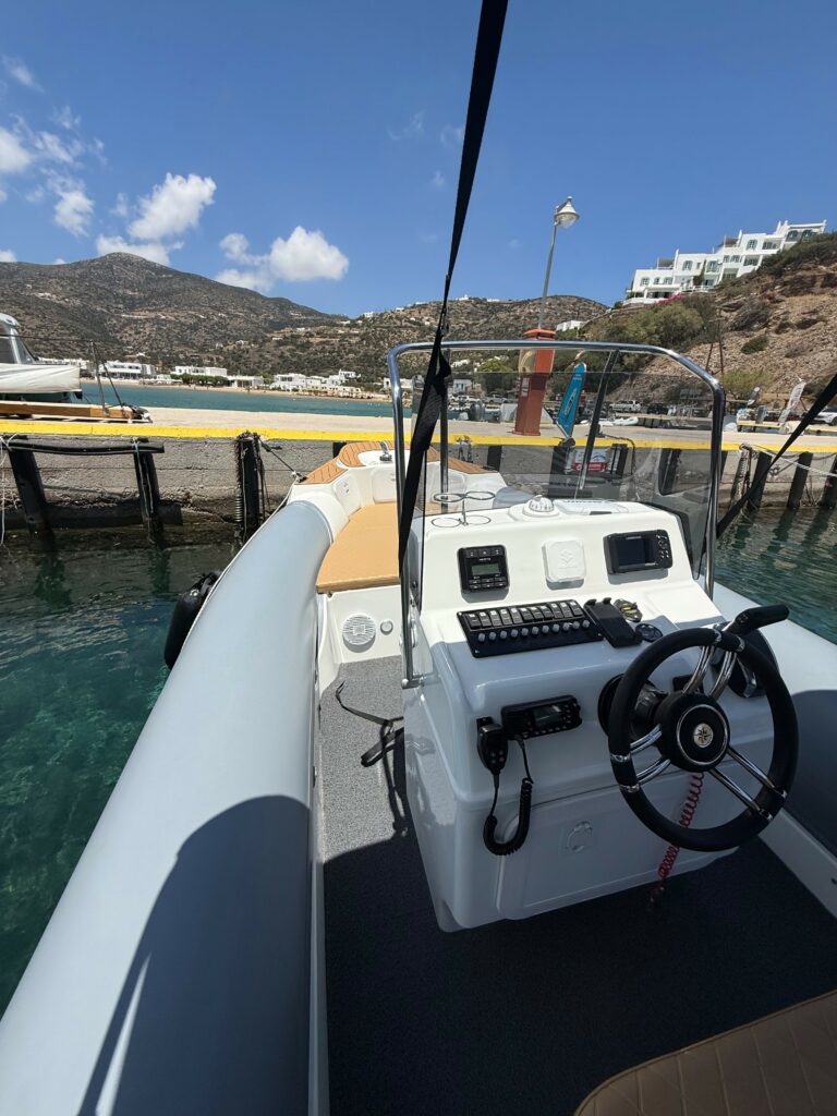 A La Mer Azur — boat rental in Sifnos, angled view of the console and deck with a beach behind