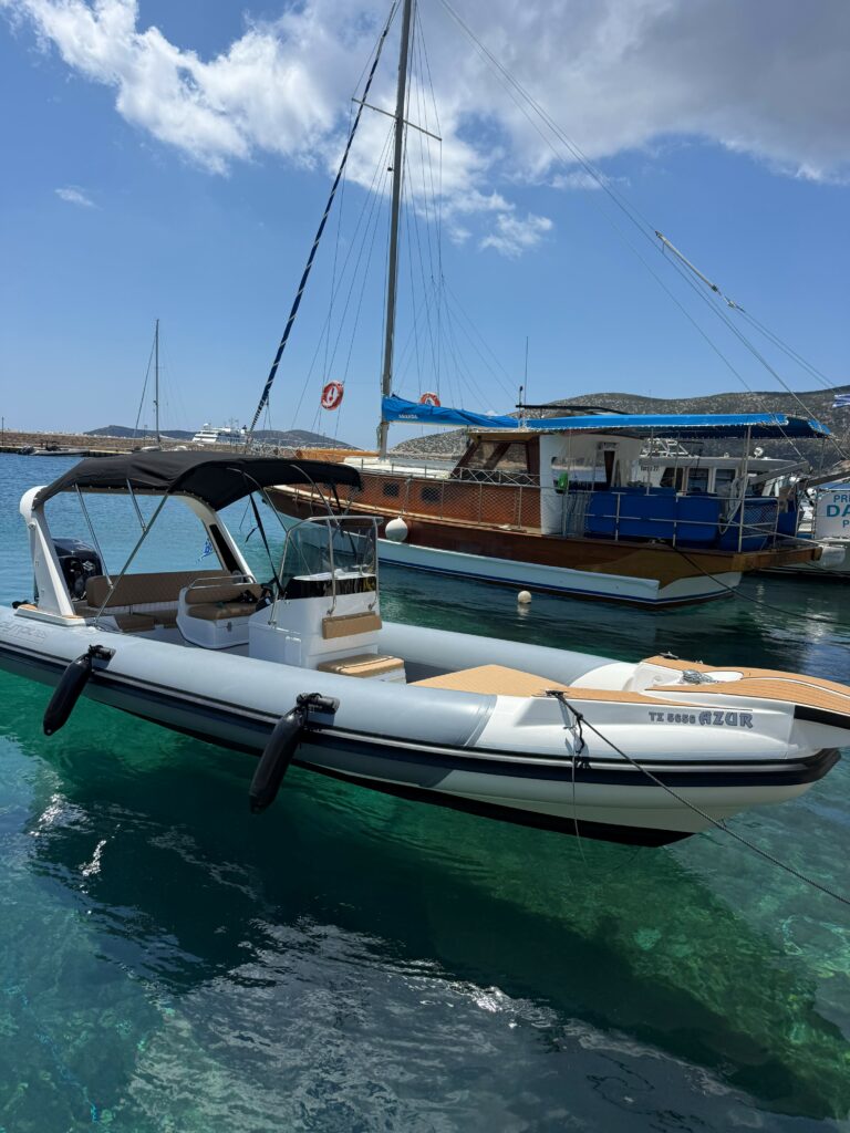 A La Mer Azur — premium boat rental in Sifnos, moored over crystal-clear turquoise water in a Cycladic harbour